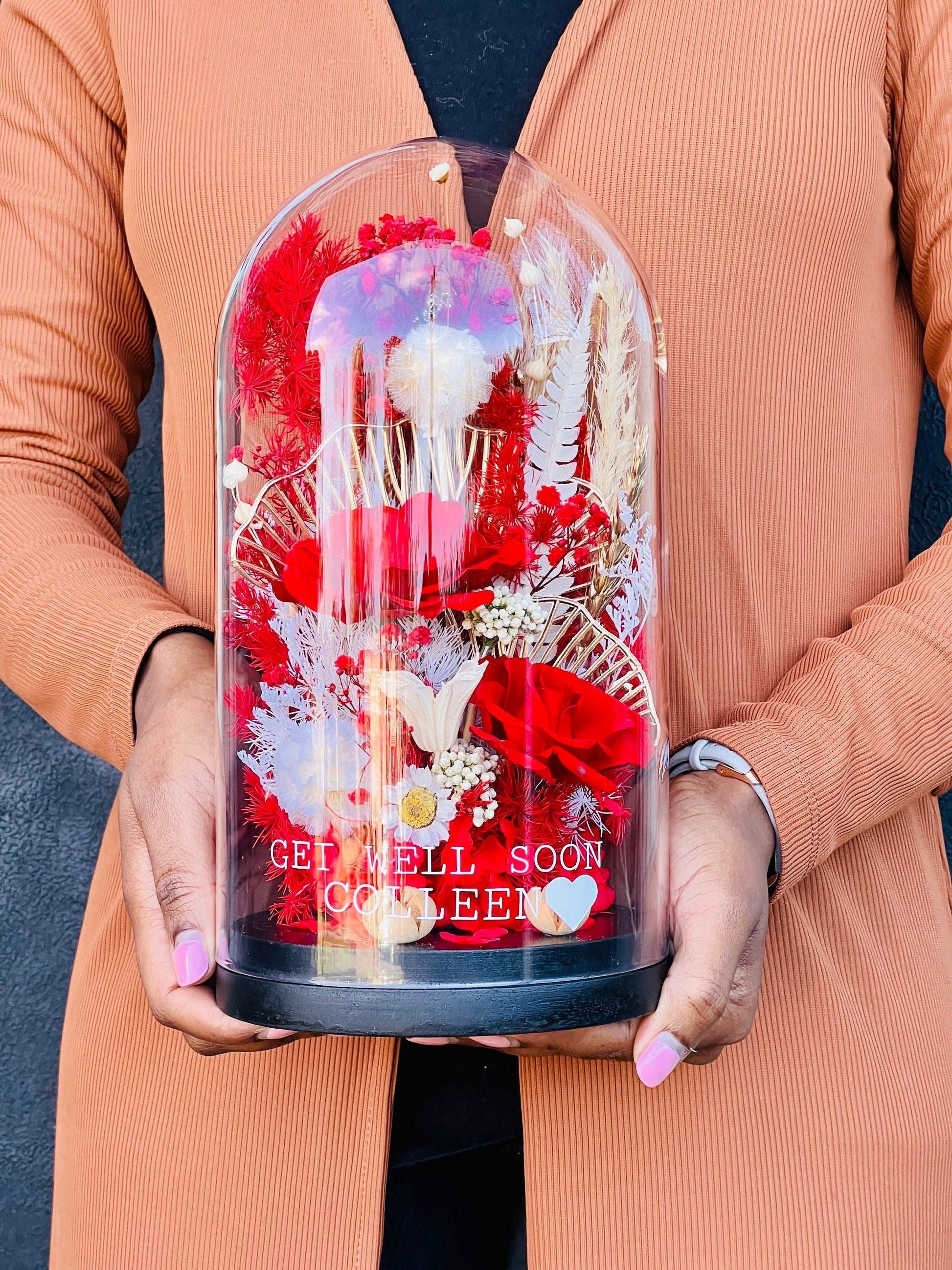 Capture the beauty of a moment in time with this red glass dome! Handcrafted with a stunning red glass dome and adorned with dried flowers, it will bring inspiration and delight to any home. Perfect for displaying your special memories.